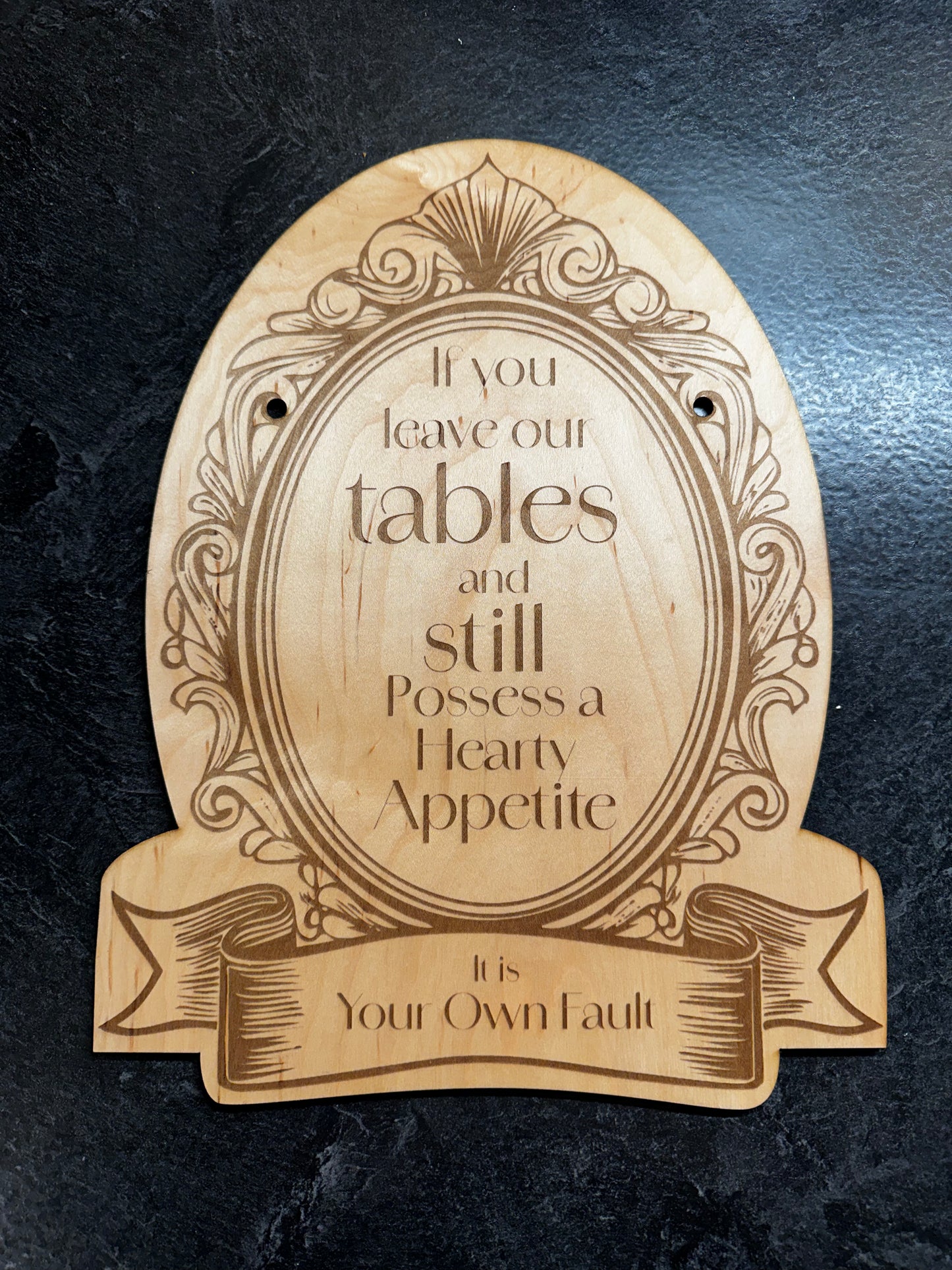 a wooden sign which reads "If you leave our tables and still possess a hearty appetite, it is your own fault."