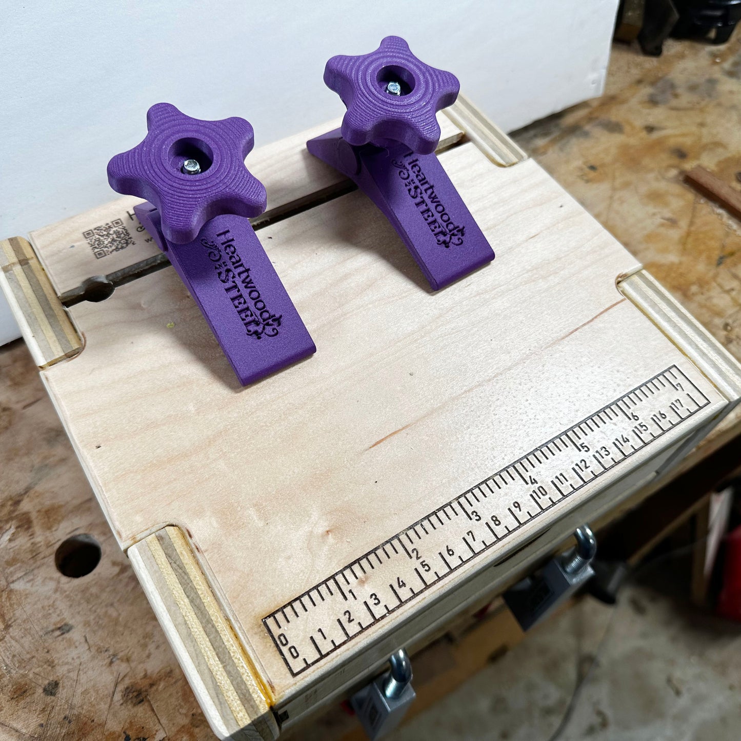 The pasta machine base with purple clamps as seen from above and showing the engraved ruler on the front edge.